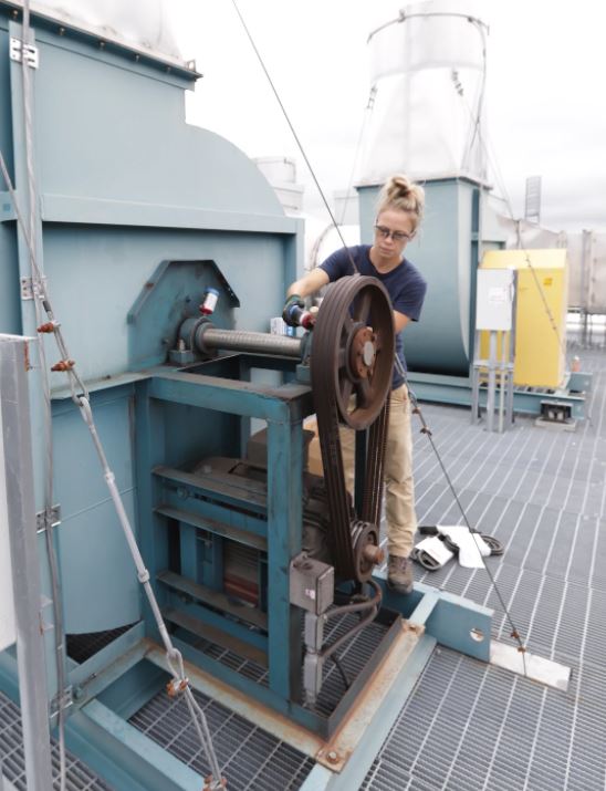 Ashley Bell works on ventilation system exhaust belts at the Chemistry Building.