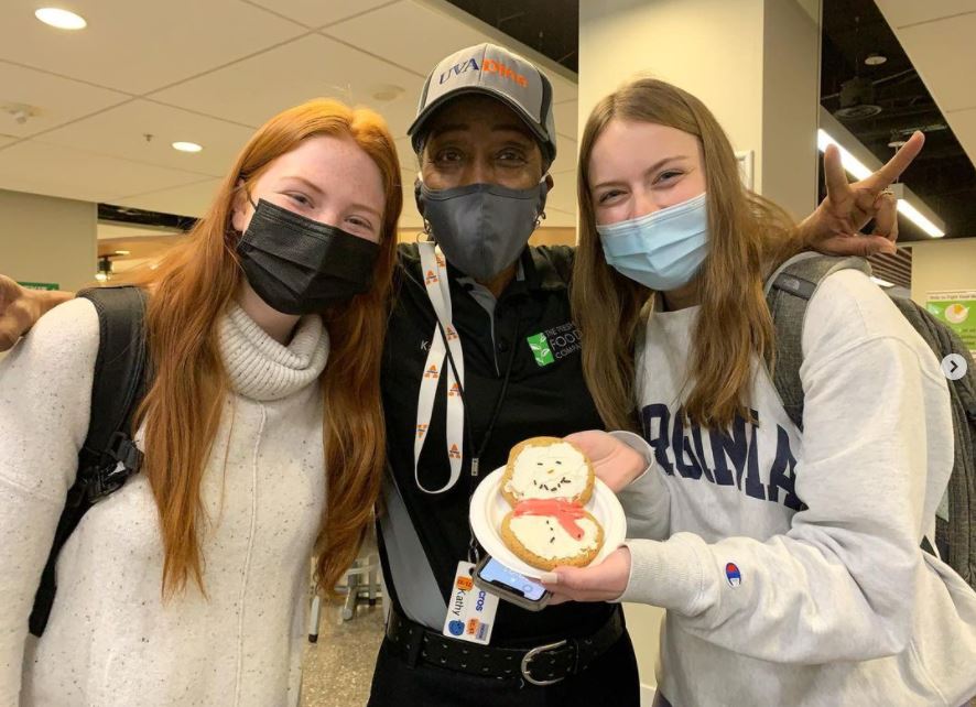 Ms. Kathy from UVA Dine with two students and a decorated snowman cookie