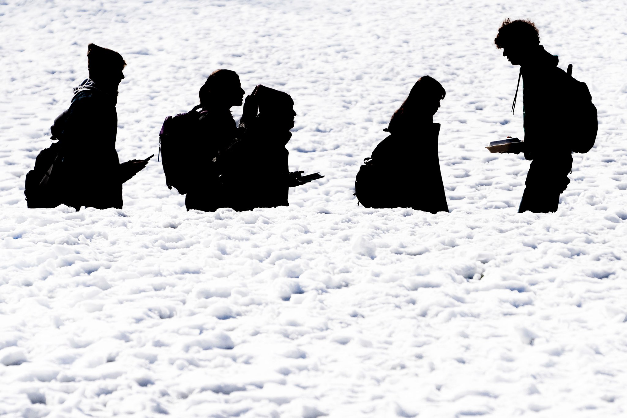students silhouetted against the snow