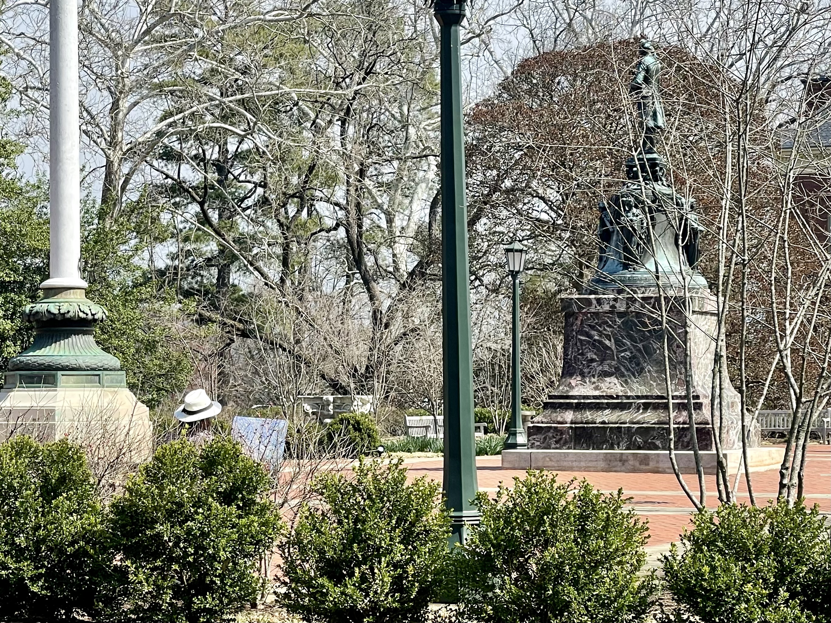 an artist sitting on a bench paints outdoors near the Rotunda