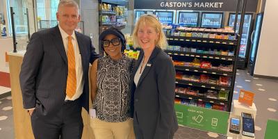 Comms VP, Retail Mgr and EVP-COO standing in front of Gaston's Mkt